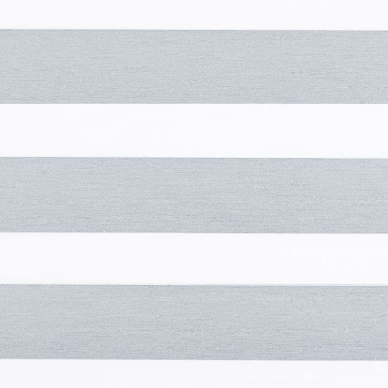 Horizontal dual-layer (zebra) roller blind covering a window, showing alternating textured gray opaque and white sheer bands that filter light; close-up view with neutral interior lighting.