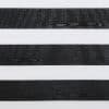 Horizontal zebra roller blind with alternating wide black wood-grain textured and white translucent bands; bands partially filter light, shown in a close-up indoor view with neutral, even lighting.
