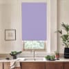 Lavender roller blind covers window, blocking light; kitchen sink and faucet sit beneath on marble counter surrounded by wooden cabinets, a framed sketch, potted plants, and a bowl of greens.