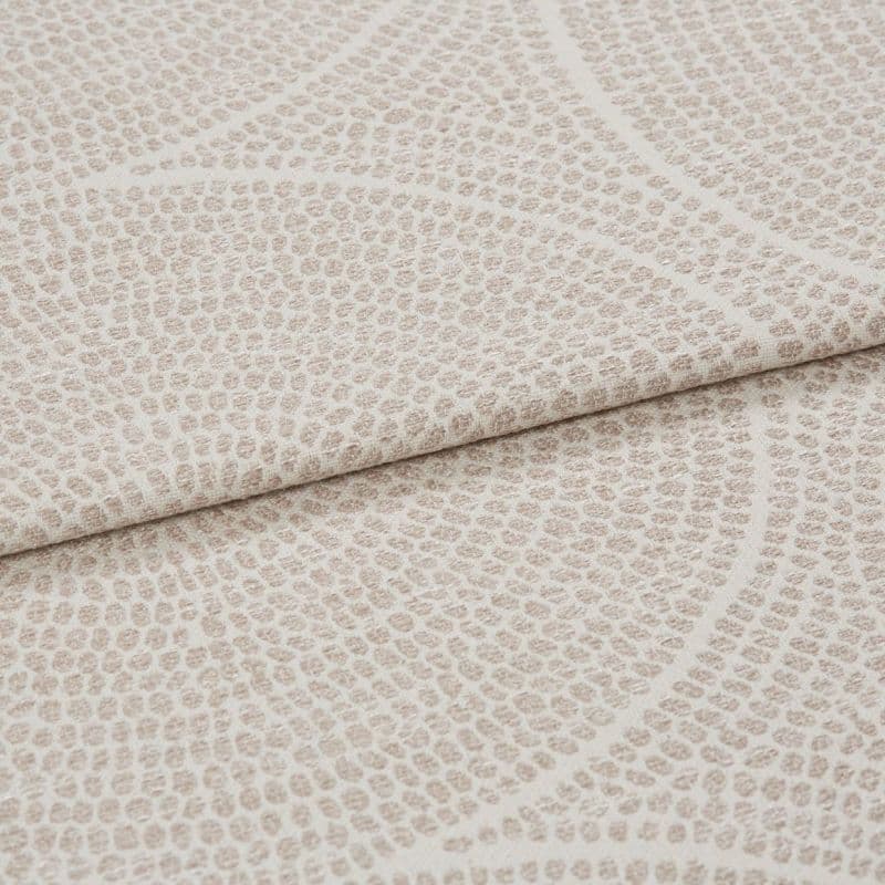 Beige textured fabric with pebble‑like raised dots and subtle curved lines; folded horizontally across the frame; close-up studio shot showing layered upholstery material in even, soft lighting.