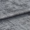 Textured metallic silver fabric folded and layered, its crushed, variegated pile shimmering and reflecting light; close-up studio view with soft lighting and a neutral background.