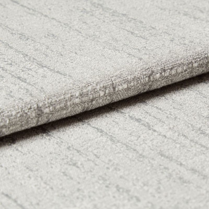 Light-gray textured fabric panel with subtle vertical stripes and stitched horizontal fold — folded over to form a crisp edge — close-up view with soft, even lighting on a neutral surface.