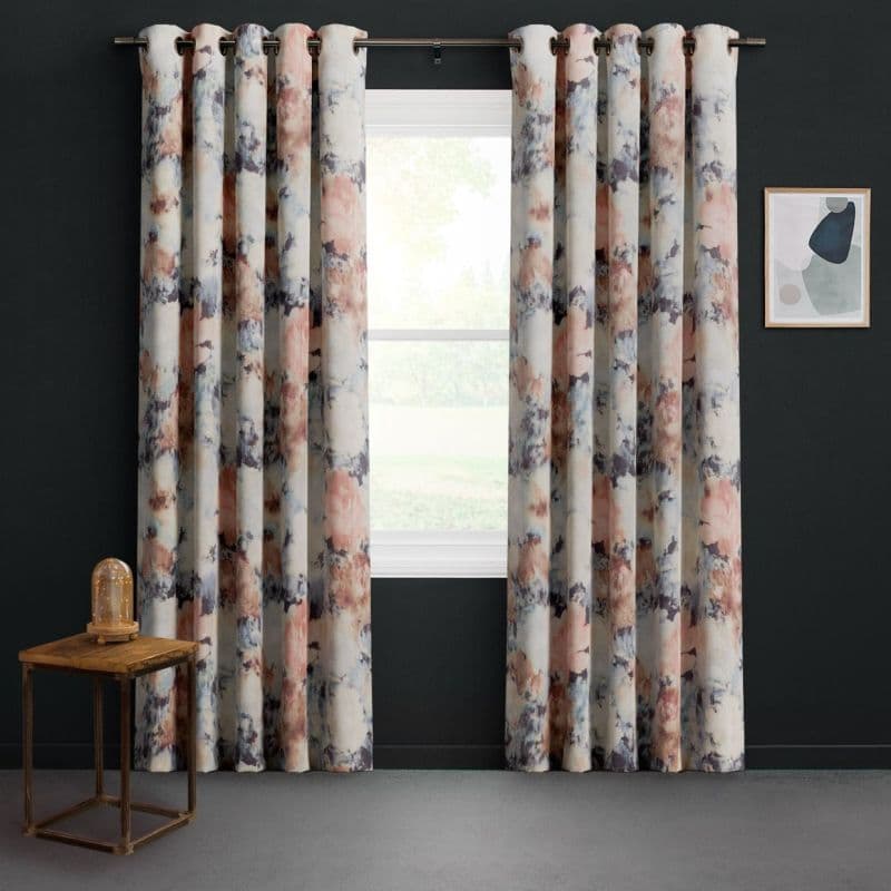 Grommet-top watercolor-patterned curtains, full-length and hung on a metal rod, parted slightly to expose a bright window; dark-painted wall, small wood side table with glass lamp and framed abstract art.