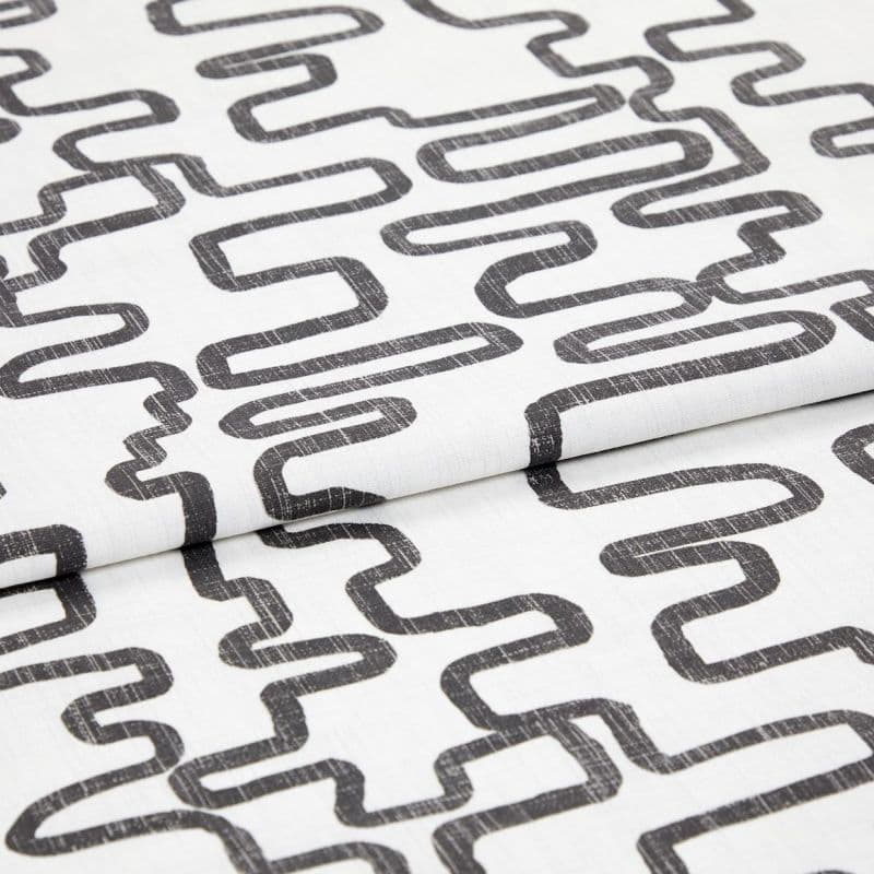 White woven fabric printed with charcoal, distressed looping-rectangle pattern, folded to show overlapping layers; studio close-up with even soft lighting and neutral background.