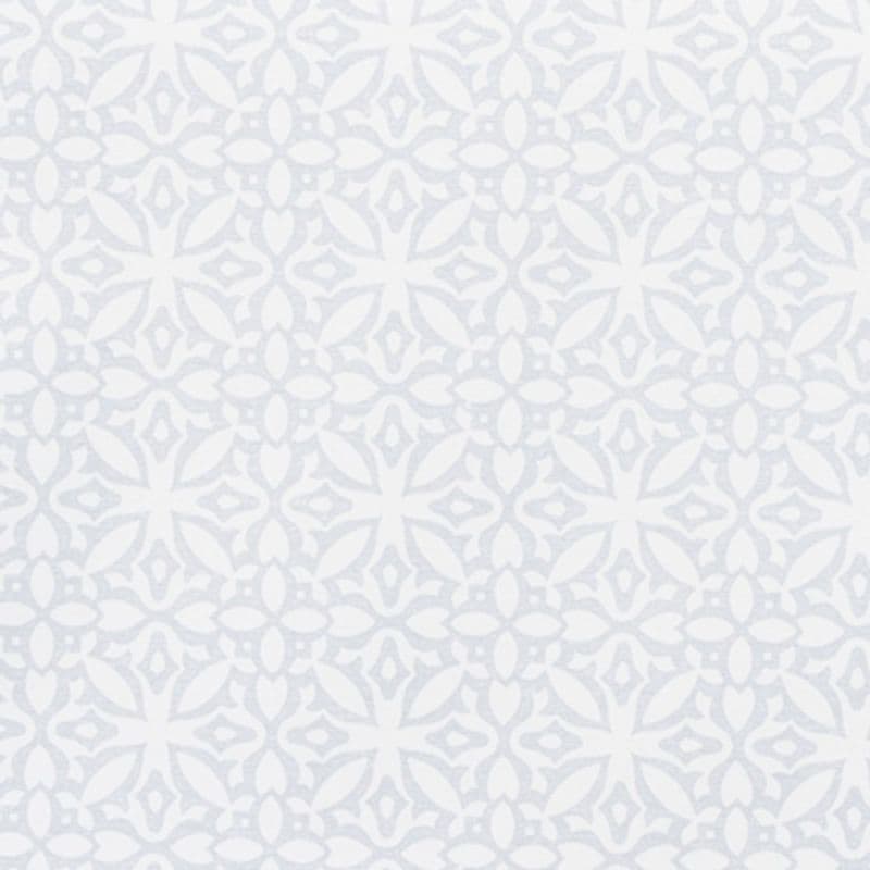 Pale gray-blue stenciled wallpaper with a repeating floral-medallion motif covers the entire surface, creating a subtle textured pattern; interior wall, evenly lit with soft, diffused daylight.