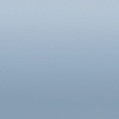Smooth pale blue gradient surface occupying the frame; shading transitions from lighter at top to slightly darker bottom; evenly lit, featureless field resembling sky or painted wall.
