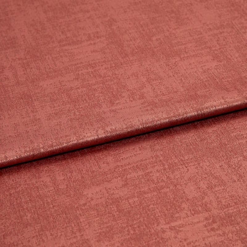 Folded rose‑colored textured fabric, a soft velvet-like material with a horizontal overlap fold; lit evenly in a close-up studio view showing subtle sheen and woven surface detail.