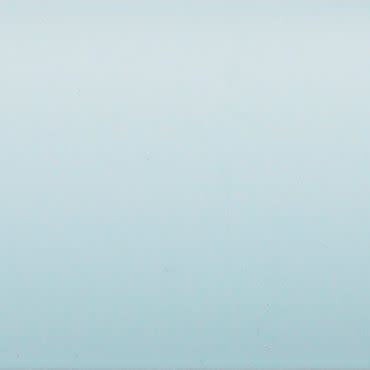 Pale blue painted wall occupying the frame, showing faint texture and a subtle vertical gradient, evenly lit and softly reflecting light in a minimal, featureless interior.