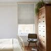Roman fabric Roman blind, lowered, textured grey, filtering soft daylight into a cozy bedroom with a pale bed, green chair, tall vintage wooden chest, and a hanging spider plant.
ASSORTED BUTTONS; ALL COLOUR BUTTONS