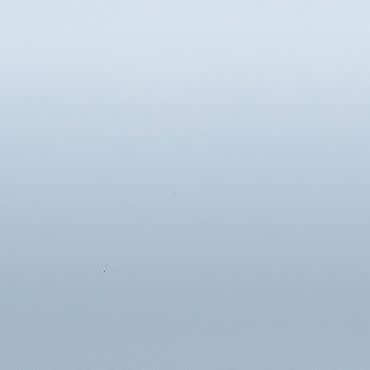 Pale blue-gray gradient surface; uniformly lit and featureless; appears as a smooth wall or sky under soft diffuse lighting with no discernible objects or depth cues.