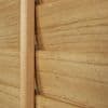 Wooden plantation shutters with a central vertical tilt rod and overlapping horizontal slats — closed, aligned to block light — close-up interior view showing warm wood grain and soft ambient light.