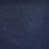 Navy-blue quilted fabric panel with narrow diagonal stitched diamonds, the quilting forming overlapping chevrons; close-up, evenly lit flat surface suggesting upholstery or textured wall covering.