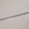 Light gray textured fabric with a small raised pebble pattern, layered in two overlapping folds; fabric lies flat with a slightly raised seam; close-up studio shot with soft, even lighting.