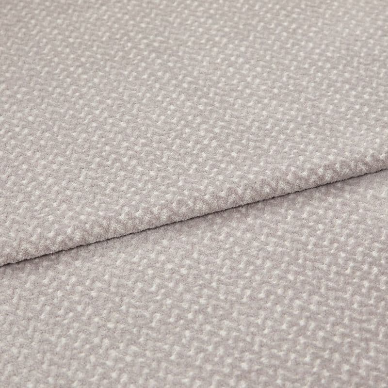 Light gray textured fabric with a small raised pebble pattern, layered in two overlapping folds; fabric lies flat with a slightly raised seam; close-up studio shot with soft, even lighting.