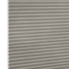 Grey honeycomb (cellular) blind, fully lowered with visible hexagonal cells along the left edge, blocking light; close-up product shot with even lighting and white background.