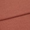 Woven terracotta textile, folded with an overlapping crease, displayed in a well-lit close-up emphasizing its fine, slightly heathered weave and flat, smooth surface.
