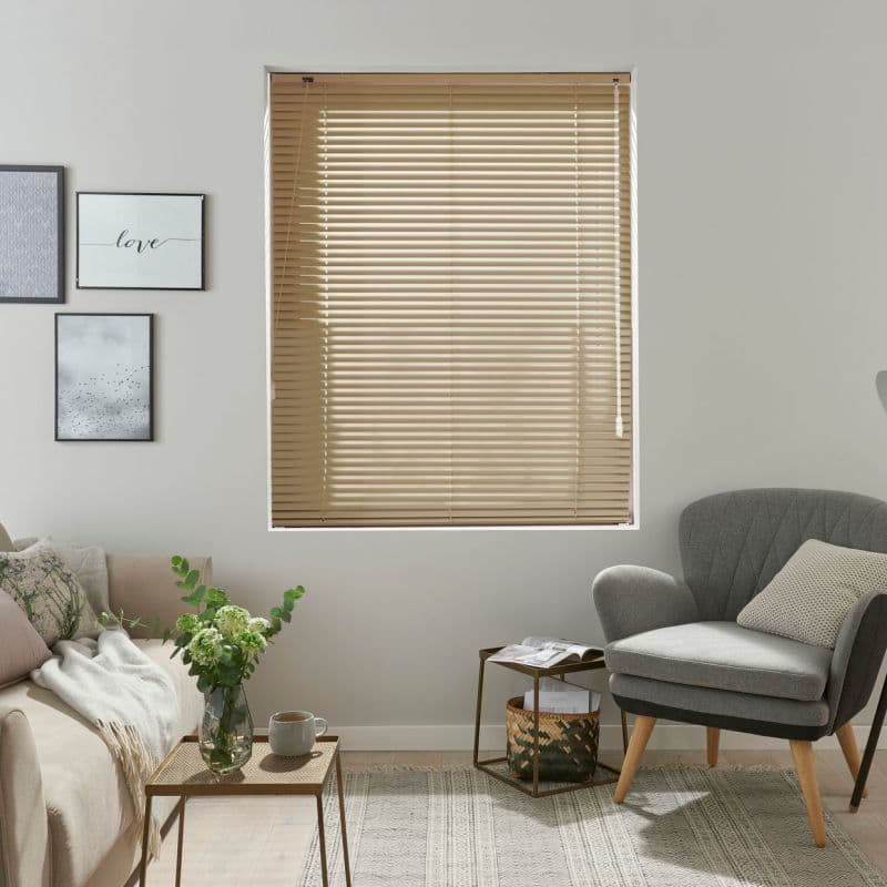 Beige horizontal slatted blinds, fully lowered with pull cords at right; closed, filtering soft daylight; neutral living room with sofa, armchair, side tables, framed art and vase.
love