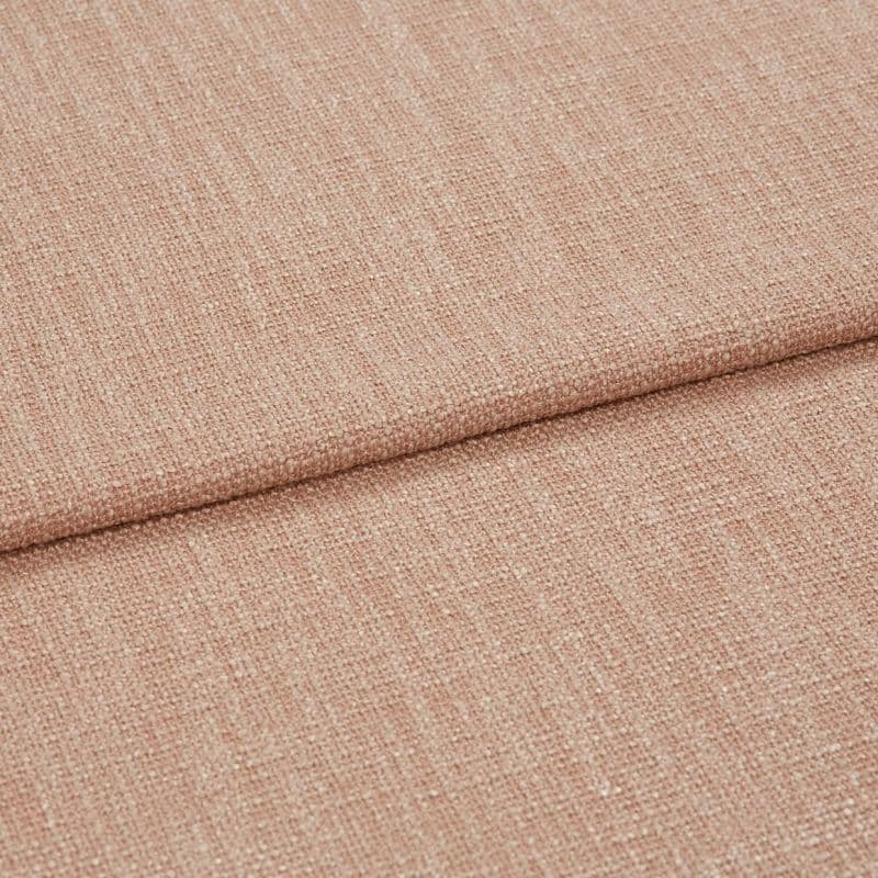 Blush-pink woven fabric folded over itself, showing a coarse textured weave; close-up studio view with soft, even lighting highlighting fibers.