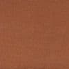 Coarse brown textured fabric occupying the entire frame; lying flat and uniform, appearing like carpet or upholstery under soft warm lighting with no other visible objects or features.