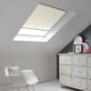 Room with white eaves wall, dark blue-grey wall to right with a shabby chic white drawer unit, a contemporary white chair, white painted floorboards and a skylight blind in natural.