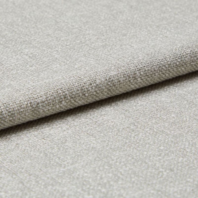 Beige woven fabric swatch, folded and layered, showing coarse basket-weave texture and subtle sheen; photographed in close-up with neutral lighting on a flat surface.