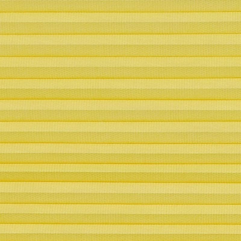 Yellow pleated cellular blind spanning the frame, horizontal accordion folds with textured fabric; fully lowered and closed, softly diffusing light in a neutral, evenly lit interior close-up with no visible view.