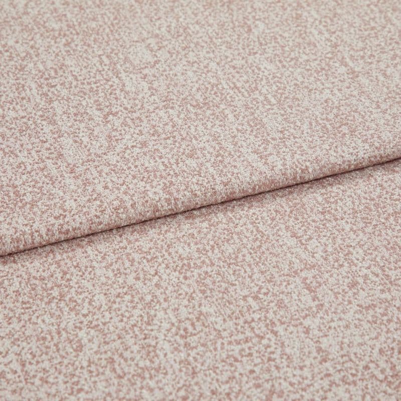 Pink-speckled upholstery fabric with a fine bouclé texture, folded and layered along a horizontal crease; lying flat in a close-up view with soft, even lighting.