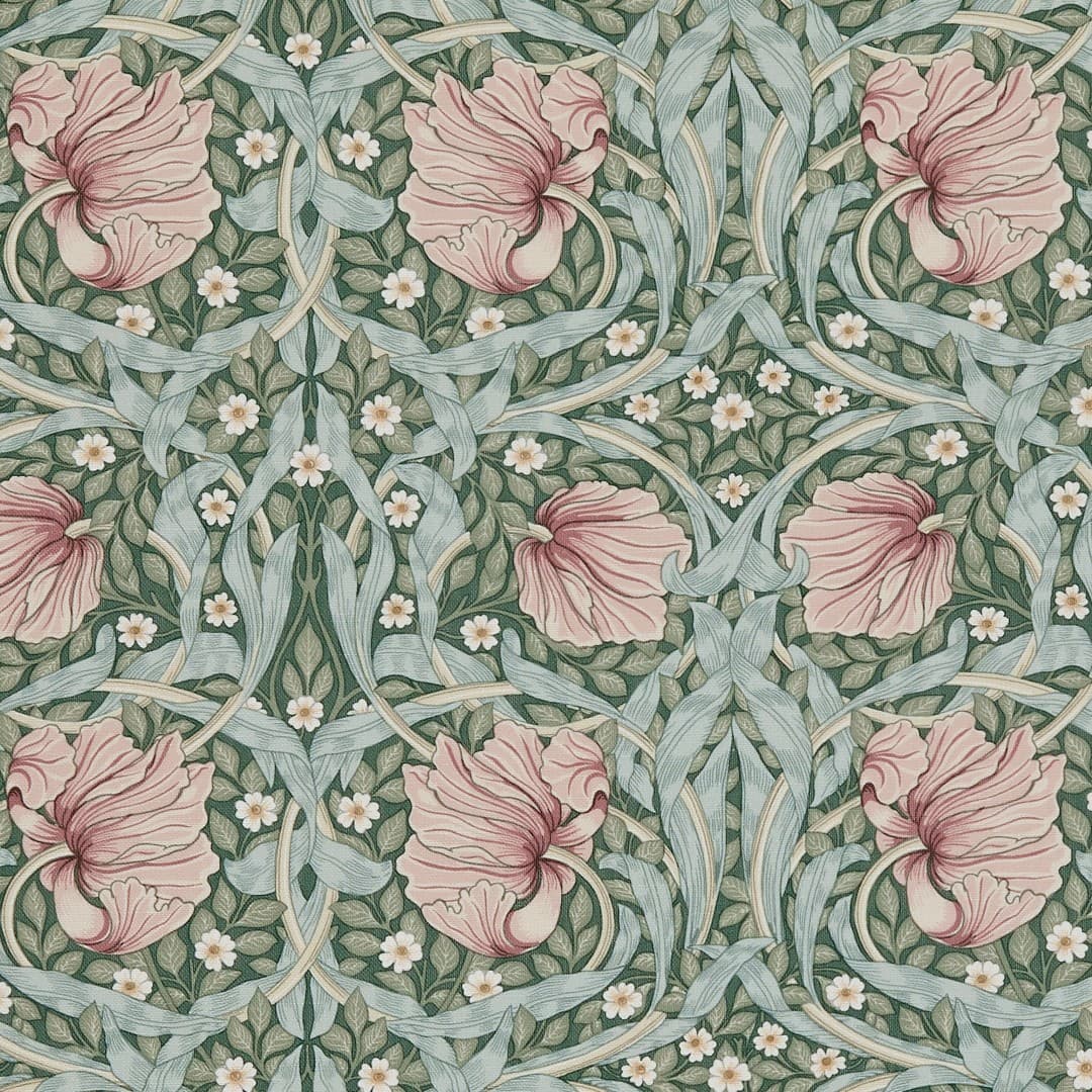 Wallpaper with large ruffled pink flowers, pale blue-green twisting leaves and tiny white blossoms — forming a symmetrical repeating pattern — on a muted green background suggesting vintage Arts-and-Crafts decor.