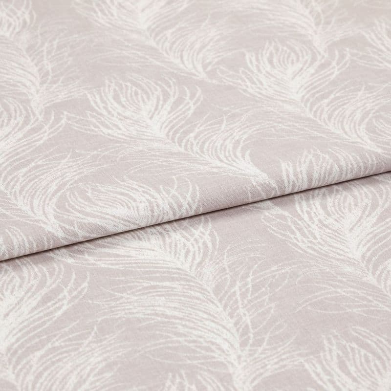 Folded pale blush fabric with white feather print (curtain/ upholstery textile), displayed flat; folds emphasize texture and repeating feather motif, shown under soft, even studio lighting.