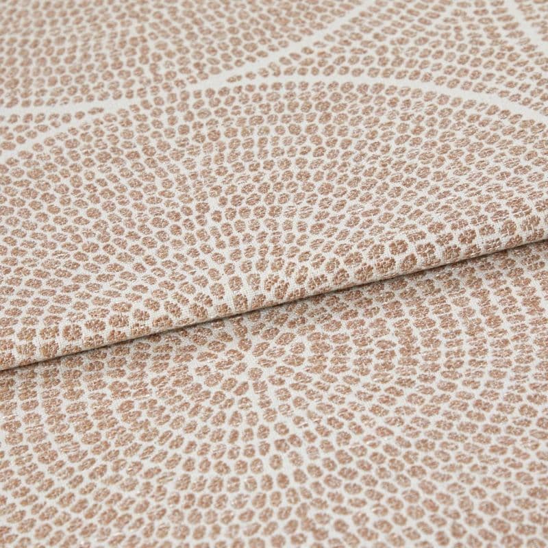 Beige and cream woven fabric with dense pebble-like dot pattern arranged in radiating rings; folded once across the frame, showing raised texture and subtle sheen in neutral studio lighting.