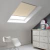 Room with white eaves wall, dark blue-grey wall to right with a shabby chic white drawer unit, a contemporary white chair, white painted floorboards and a skylight blind in pale cappucino.