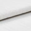 White textured fabric roll with coarse woven pattern; layered and slightly folded, resting overlapped on a matching textured surface in bright, diffuse studio lighting, close-up detail.
