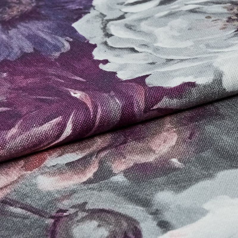 Folded floral-printed canvas fabric (textured weave), edge overlapping and creating a ridge; showing white and purple peony-like petals in a close-up macro view with soft, even lighting.