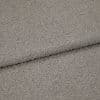 Gray boucle upholstery fabric folded to show an overlapping edge; dense looped texture; close-up, evenly lit studio view of a neutral-colored textile surface.
