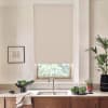Beige patterned roller blind hangs over a kitchen window, blocking light; stainless faucet and double sink on marble countertop, with bowls of cabbage, potted plants, towel, and framed sketch nearby.
