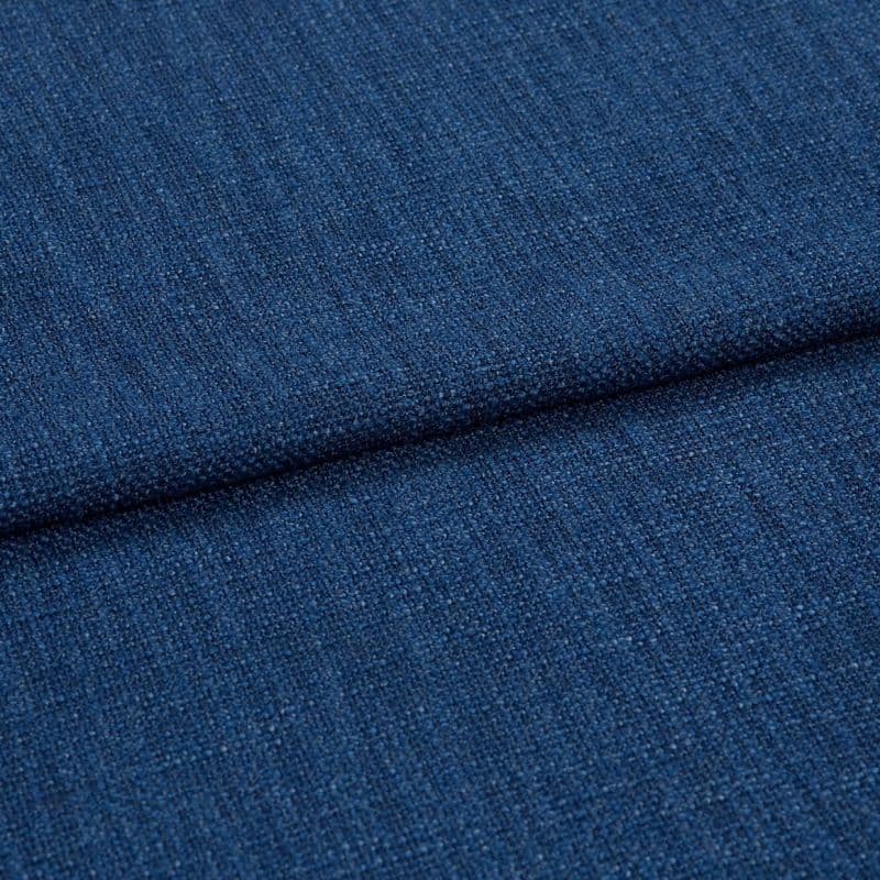 Blue textured upholstery fabric (tight weave) folded across the frame, showing a horizontal crease; close-up studio-lit view emphasizing coarse threads and uniform deep-blue color.