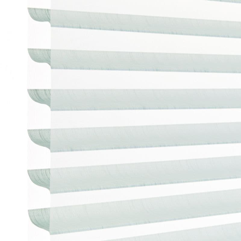 Layered horizontal zebra blind with alternating pale aqua translucent and opaque white fabric stripes, hanging lowered; filtering daylight and softly diffusing light in a bright, minimal indoor setting.