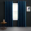 Floor-length navy grommet curtains on a metal rod, parted to reveal bright daylight through a white-framed window; dark-gray room with a small wooden side table and framed abstract art.