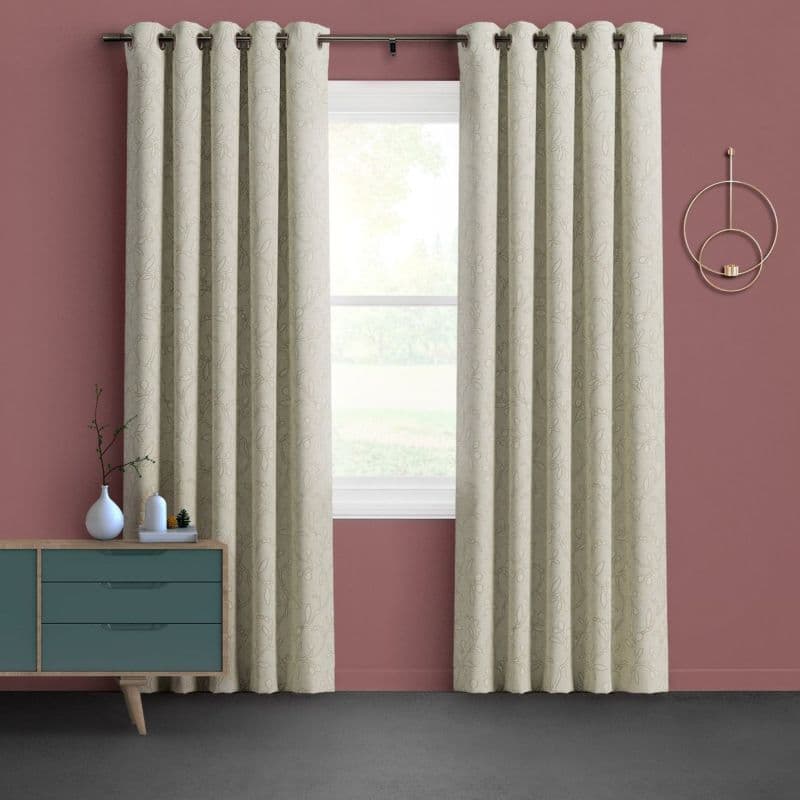 Grommet-top beige patterned curtains, hanging and slightly parted on a metal rod, framing a bright single-pane window; room with muted rose walls, teal midcentury sideboard, circular wall decor, soft daylight.