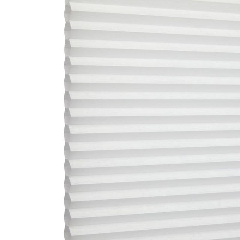 White honeycomb (cellular) blind with horizontal pleats, closed and softly diffusing daylight; minimal, bright interior with no visible furniture or view.