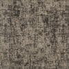 Woven gray-beige upholstery fabric close-up showing irregular black crosshatch and speckled pattern, revealing a coarse diagonal twill weave texture across a flat, evenly lit surface.