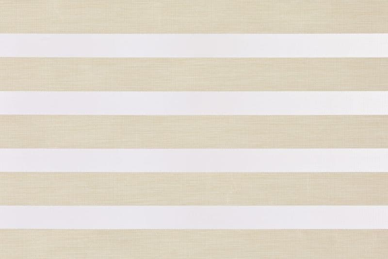 Horizontal dual-layer zebra roller blind with alternating opaque white and sheer beige textured bands, partially closed, filtering soft daylight in a neutral-lit interior.