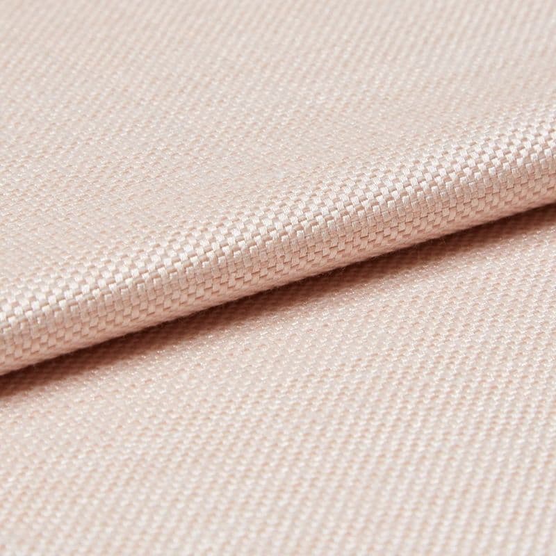 Light peach woven fabric with tight basket weave, folded in a shallow overlap; soft sheen catches diffused studio light, close-up view emphasizing texture and gentle drape.