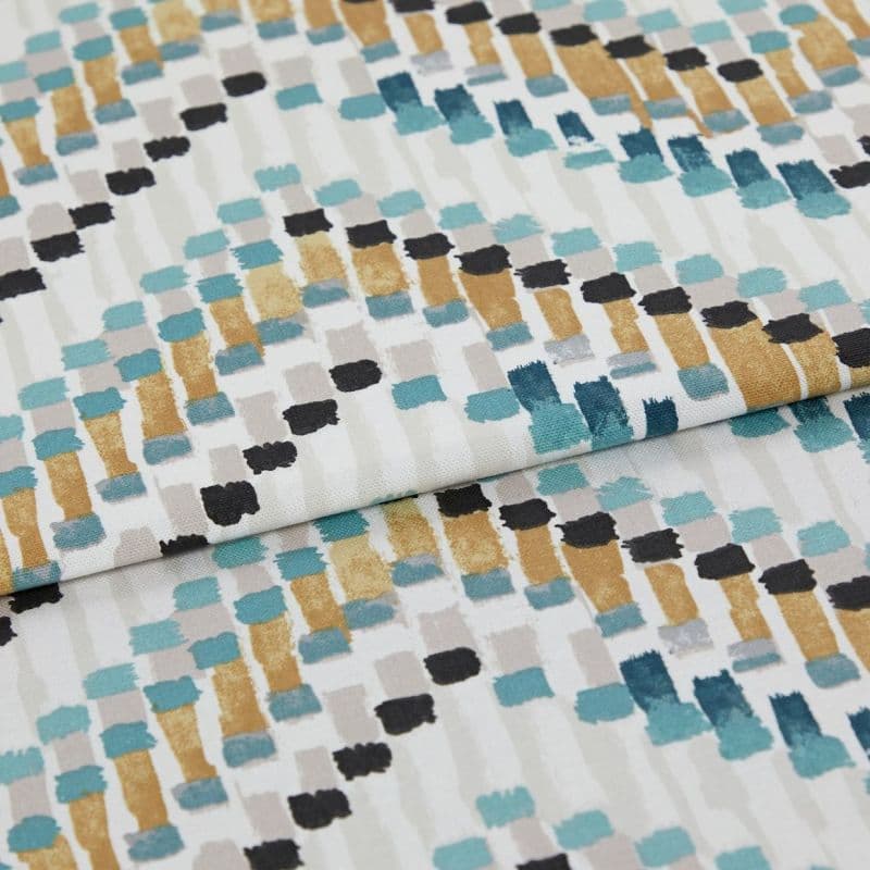 Fabric with abstract rectangular brushstroke pattern (teal, mustard, black, gray) — folded across the frame — close-up studio shot showing textured cotton/linen surface and even soft lighting.