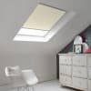 Room with white eaves wall, dark blue-grey wall to right with a shabby chic white drawer unit, a contemporary white chair, white painted floorboards and a skylight blind in almond.