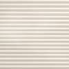 Horizontal pleated fabric blind, fully lowered and tightly closed with even ridges and beige texture; gently filtering soft daylight; fills a window opening in a neutral, softly lit interior.