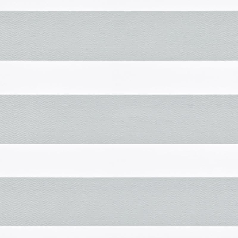 Horizontal-striped zebra roller blind, lowered across the window with alternating light-gray sheer and white opaque bands; diffusing and partially blocking daylight, set against a neutral, minimally detailed interior.