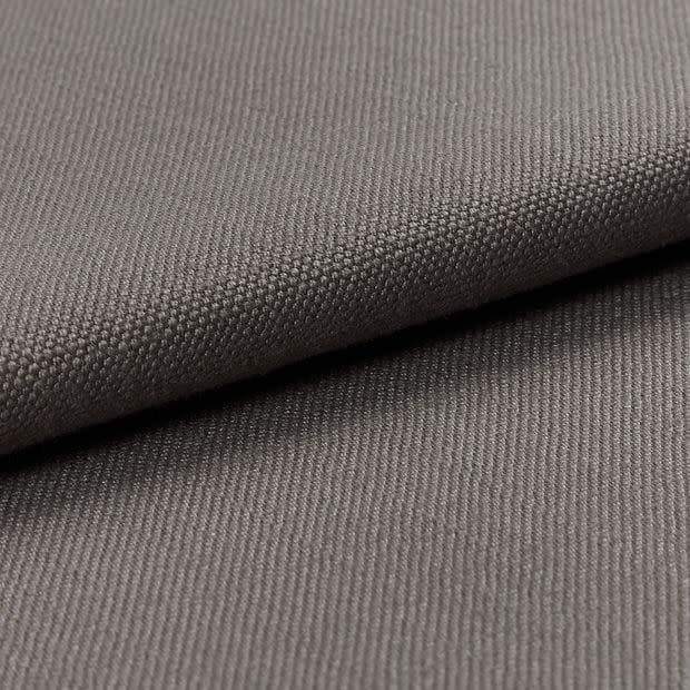 Gray woven fabric (canvas-like), folded diagonally over itself, showing dense pebble and twill textures; soft, even studio lighting highlights fine weave in a close-up, neutral setting.