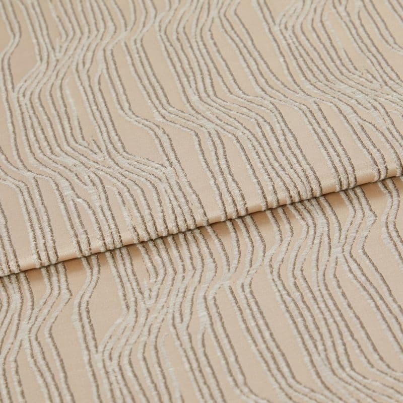 Beige textured fabric with raised, irregular wavy stripes—folded once across the middle—close-up view of a textile sample under soft, neutral studio lighting.