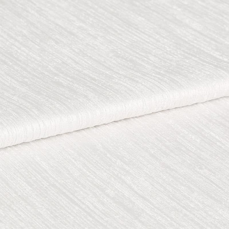 White ribbed textured fabric, folded in overlapping layers showing subtle horizontal sheen; lying stacked on itself, photographed in close-up under soft, even studio lighting with a neutral background.
